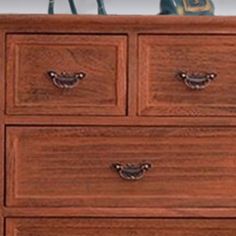 a wooden dresser with three drawers on top of it