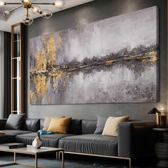 a living room filled with furniture and a large painting hanging on the wall above it