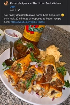 a white plate topped with lots of food on top of a counter next to a bottle of beer