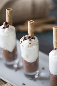 three desserts in small glasses on a tray