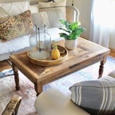 a living room filled with furniture and a coffee table in front of a white couch