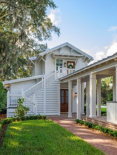 a white house with columns on the front and stairs leading up to it's entrance