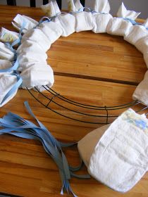 a baby diaper wreath on a wooden table