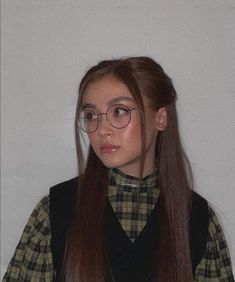 a girl with long hair wearing glasses and a plaid shirt