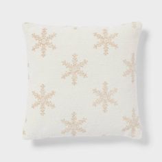 a white and gold pillow with snowflakes on it