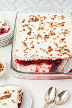 there is a cake with white frosting and toppings on the table next to other desserts