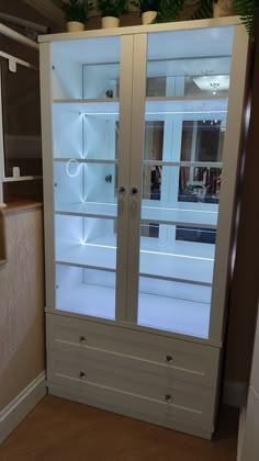 a white cabinet with glass doors in a room