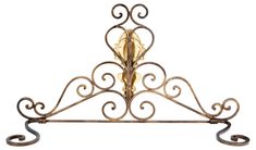 an ornate iron shelf with two candles on it's sides and one candle in the middle