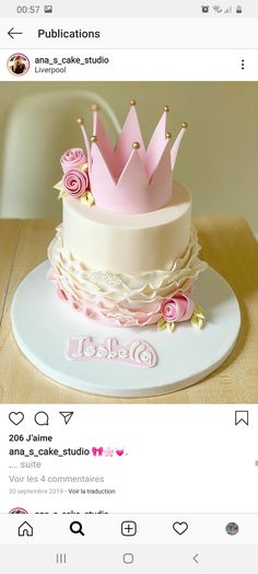 the cake is decorated with pink flowers and a crown