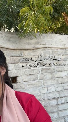 a woman wearing a pink scarf and smiling at the camera with an arabic writing above her head