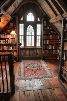 an attic room with wooden floors and lots of books on the shelves, along with a large rug