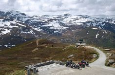 three motorcycles parked on the side of a mountain road