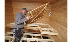 a man is working on the inside of a saunage with wood planks