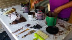 a table topped with lots of paint and tools