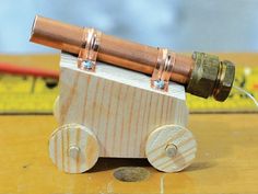 a small wooden toy with a telescope on it's back and some metal fittings