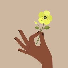 a person's hand holding a flower in front of a brown background with yellow flowers