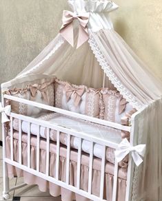 a baby crib with pink and white bedding