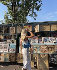 a woman standing in front of a book stand