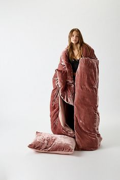 a woman wrapped in a large pink blanket