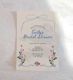 a bridal shower is displayed on a white sheet with blue writing and flowers in the center