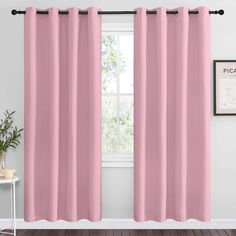 a pink curtain hanging in front of a window