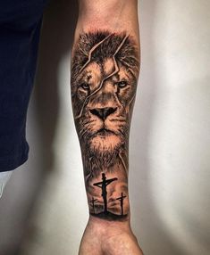 a man's arm with a lion and cross tattoo on the left side of his arm