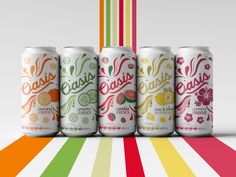 four cans of various flavored beverages on a multi - colored striped background