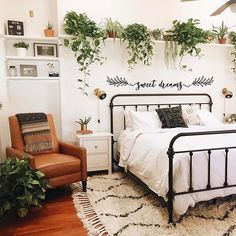 a bed room with a neatly made bed and lots of plants on the wall above it