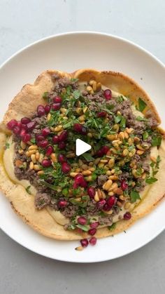 a white plate topped with pita bread covered in meat and vegtables