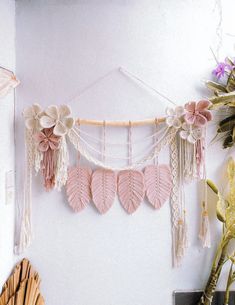 a wall hanging with pink hearts and tassels attached to it's sides