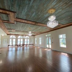 an empty room with wood floors and chandelier