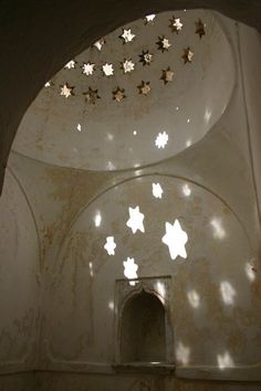 the interior of an old building with stars on the ceiling and light coming through it