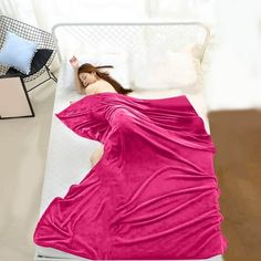 a woman in a pink dress laying on a bed