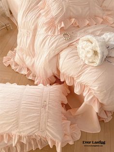 two pink bedspreads with ruffled edges and a flower on the headboard