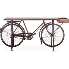 an old fashioned bicycle sitting on top of a wooden table