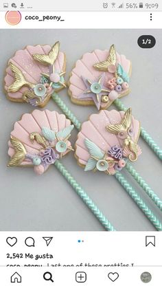 four pink and blue mermaid themed cookies on top of each other with seashells