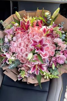 a bouquet of pink flowers sitting on top of a car seat