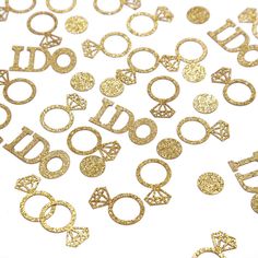 some gold glittered letters and numbers on a white surface with small circles around them