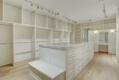 an empty room with white cabinets and drawers