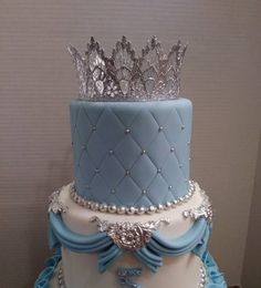 a blue and white cake with a crown on top