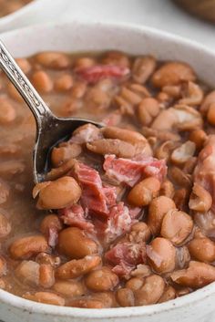 a white bowl filled with beans and ham