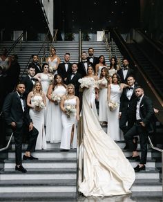 a large group of people in formal wear posing on stairs