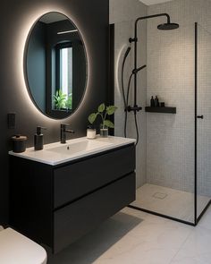 a black and white bathroom with a round mirror
