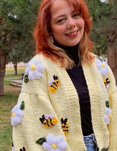 a woman with red hair wearing a yellow cardigan