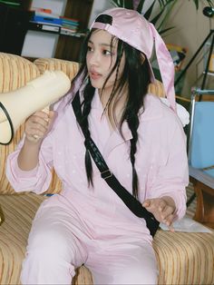 a woman in bunny ears sitting on a couch with a hair dryer behind her head