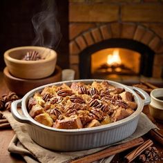 a casserole dish with pecans and cinnamon in front of a fire place