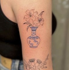 a woman's arm with a vase and flowers on it