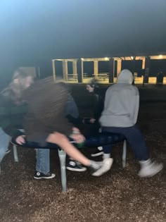 two people sitting on a bench at night