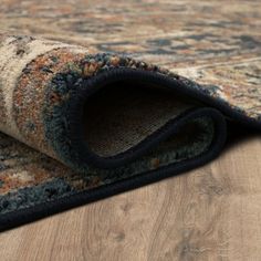 an area rug is laying on the floor with it's end rolled up to show its