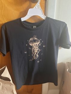 a t - shirt with an image of a jellyfish hanging on a clothes rack